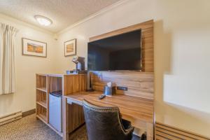 a hotel room with a flat screen tv and a desk at Alpenhof Lodge in Mammoth Lakes