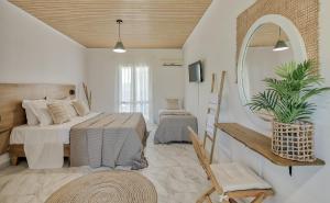 a bedroom with two beds and a mirror at Santa Maroma Rooms & Houses in Vasilikos