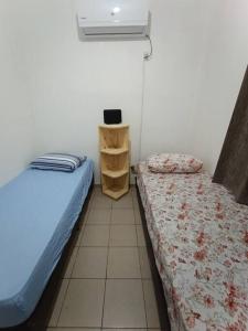 a room with two beds and a book shelf at departamento céntrico in Puerto Iguazú