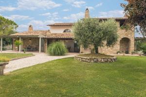 a stone house with a tree in the yard at Agriturismo Alle Mignole in Vicolo Rancolfo