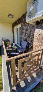 a patio with a table and chairs and a stone wall at Holiday House Berekfürdő in Berekfürdő