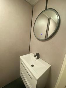 een badkamer met een wastafel en een spiegel aan de muur bij Next To Sea in Vlissingen