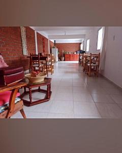 pusty pokój z drewnianymi krzesłami i stołami w obiekcie Hospedaje Las Dalias w mieście San José