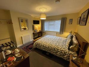 a bedroom with a bed and a table and a window at The Old Posthouse B&B in Caenby