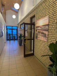 an office lobby with a brick wall and a door at Wohnwagen auf dem Wulfenerhals in Fehmarn