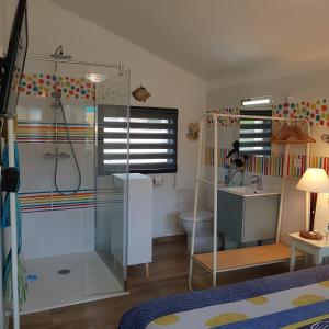 a bathroom with a shower and a sink and a toilet at LE jardin in Coudeville