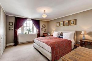 a bedroom with a large bed and a window at Royal Regency Residence - Sleeps 8 in London