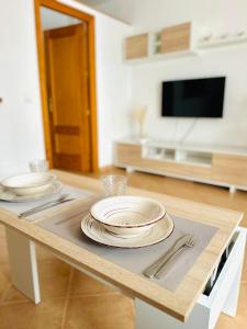 uma mesa com pratos e utensílios em cima em Centre Village Apartment em La Cala de Mijas