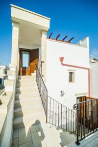 un escalier menant à une maison blanche dans l'établissement B&B Il Granaio, à Nociglia