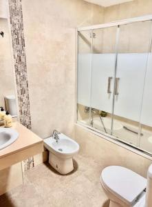 een badkamer met een toilet, een wastafel en een douche bij Candela Beach Luxury Apartament in Motril