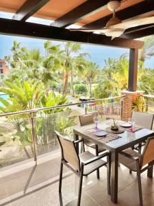 een eettafel en stoelen op een balkon met uitzicht bij Candela Beach Luxury Apartament in Motril