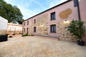 a pink building with a brick driveway at Casa Vacanze Nonno Antioco - USO ESCLUSIVO in Gonnosfanàdiga