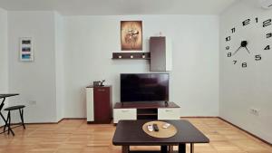a living room with a tv and a coffee table at Apartament Confort Hd in Hunedoara