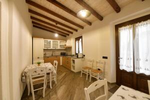 a kitchen and dining room with a table and chairs at Casa Vacanze Nonno Antioco - USO ESCLUSIVO in Gonnosfanàdiga