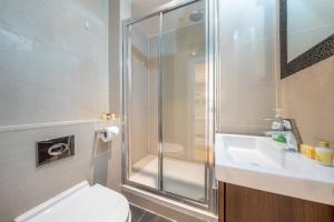 a bathroom with a shower and a toilet and a sink at Exclusive 2-Bedroom Apartment in London