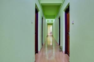 um corredor vazio com paredes verdes e pisos de madeira em SUBY PLAZA em Tāmarakulam