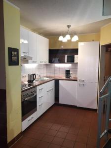 a kitchen with white cabinets and a stove top oven at Ferienhaus in Zandt mit Kleiner Terrasse in Zandt