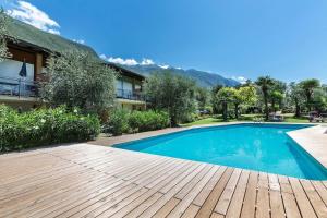 una piscina in un cortile con terrazza in legno di Tolle Wohnung in Malcesine mit Garten, Grill und gemeinschaftlichem Pool a Malcesine