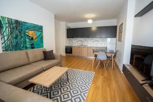 a living room with a couch and a table at Shkodra Harmony Residences in Shkodër
