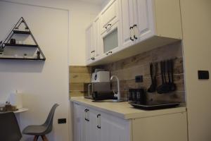 a kitchen with white cabinets and a sink at Apartman Suny N58- SPA -Gratis in Kopaonik