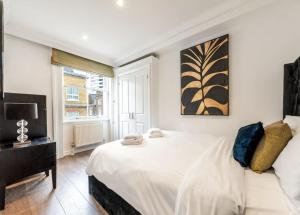 a bedroom with a large white bed and a window at Exclusive 2-Bedroom Apartment in London