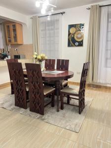 een eetkamer met een houten tafel en stoelen bij The comfortplace Naivasha in Naivasha