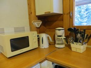a kitchen counter with a microwave and appliances on it at Cottage-karaoke Koivikko in Äänekoski