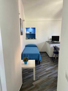 um quarto com uma cama azul e uma secretária em Casa vacanze centro storico Procida em Procida