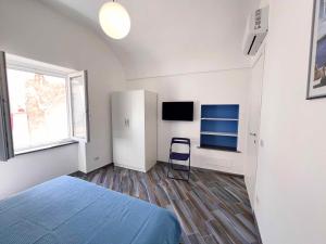 1 Schlafzimmer mit einem Bett, einem Fenster und einem TV in der Unterkunft Casa vacanze centro storico Procida in Procida