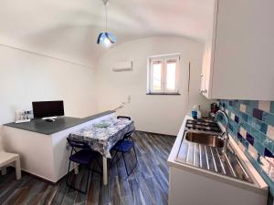 eine kleine Küche mit einem Tisch und einem Waschbecken in der Unterkunft Casa vacanze centro storico Procida in Procida