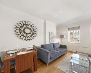a living room with a blue couch and a table at Exclusive 2-Bedroom Apartment in London