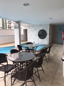 ein Zimmer mit Tischen und Stühlen sowie einem Pool in der Unterkunft Ap Estilo & conforto vista piscinas in Caldas Novas