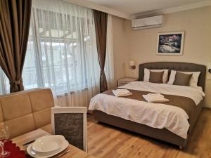 Un dormitorio con una cama grande y una ventana en Family Boutique Residence-Free parking en Veliko Tŭrnovo