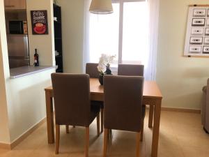 een eettafel met stoelen en een keuken bij Vista al Lago by COSY in Alhama de Murcia