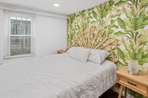 a bedroom with a bed with a floral wallpaper at Quiet Convenient 2-Family House - Tropical Design in Atlantic City