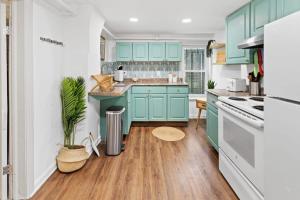 a kitchen with blue cabinets and a wooden floor at Quiet Convenient 2-Family House - Tropical Design in Atlantic City