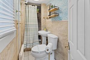 a bathroom with a toilet and a sink at Quiet Convenient 2-Family House - Tropical Design in Atlantic City