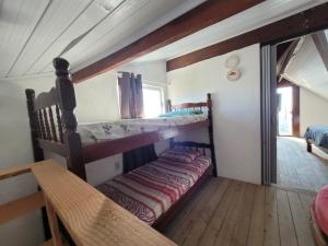 a bedroom with two bunk beds and a window at mirante por do sol in São Thomé das Letras