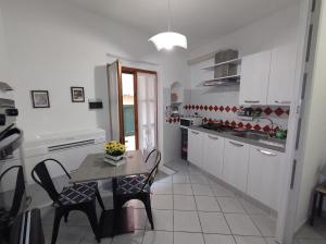 a kitchen with a table and chairs in a kitchen at Monolocale Poggio in Marciana