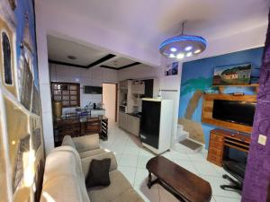a living room with a couch and a tv at mirante por do sol in São Thomé das Letras
