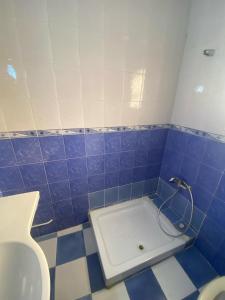 baño de azulejos azules con lavabo y aseo en NARCISSE RESIDENCE, en Hammam Sousse