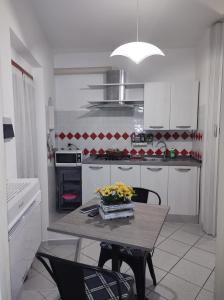 uma cozinha com uma mesa com flores em Monolocale Poggio em Marciana