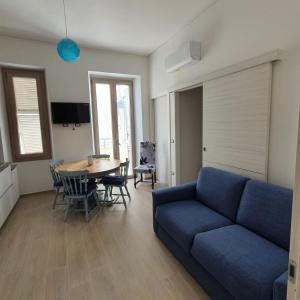 a living room with a blue couch and a table at ILLY HOUSE in Alghero