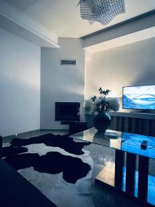 a living room with a glass table and a television at Koliba apartments in Bratislava