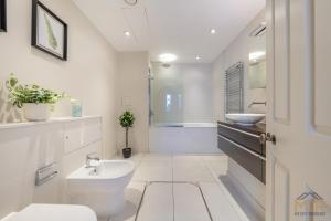 a white bathroom with a sink and a toilet at Royal 4 Bedroom Apartment in Mayfair in London