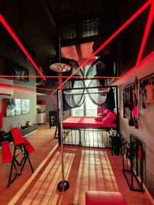 ブラチスラヴァにあるBDSM apartmán v Bratislave -ADULTS ONLYの赤いベッドと赤い椅子が備わる客室です。