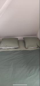 a white bed with two pillows on top of it at Le petit Treguier in Tréguier