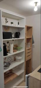 a kitchen shelving unit with dishes and other items on it at Le petit Treguier in Tréguier