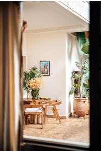 Cette chambre comprend une table, des chaises et des plantes. dans l'établissement Riad Deha & Spa, à Marrakech