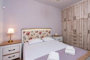 a bedroom with a white bed and wooden cabinets at House 55 in Arta